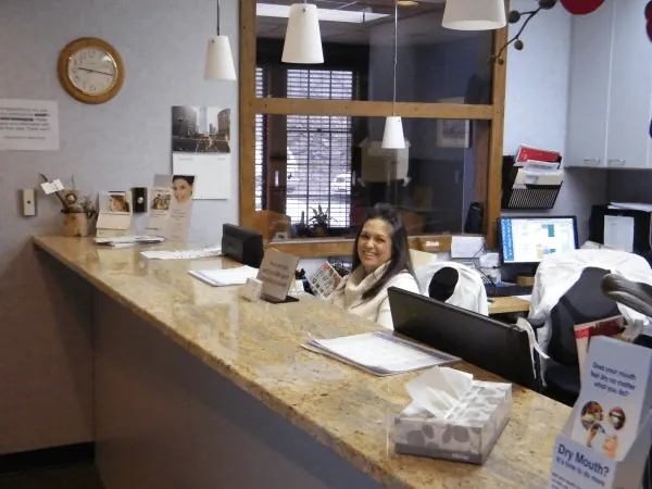 A patient coordinator at the granite front desk of Comprehensive Dental Group.
